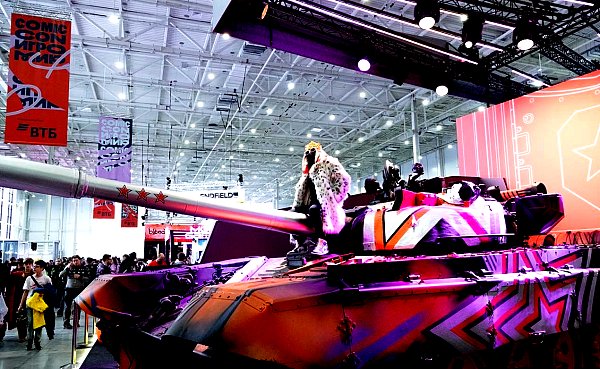Павильон Comic Con Игромир с баннерами фестиваля и раскрашенным танком в центре зала