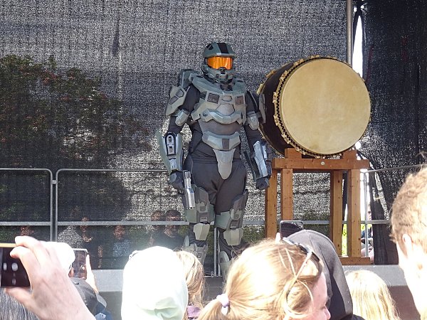 Косплеер в броне Мастера Чифа из Halo выходит на сцену конкурса косплея перед зрителями
