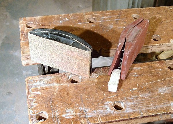 Два резиновых шлифовальных бруска со шкуркой на верстаке