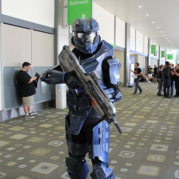 Косплеер в синей броне спартанца из Halo с закрытым шлемом и визором, в коридоре конвента
